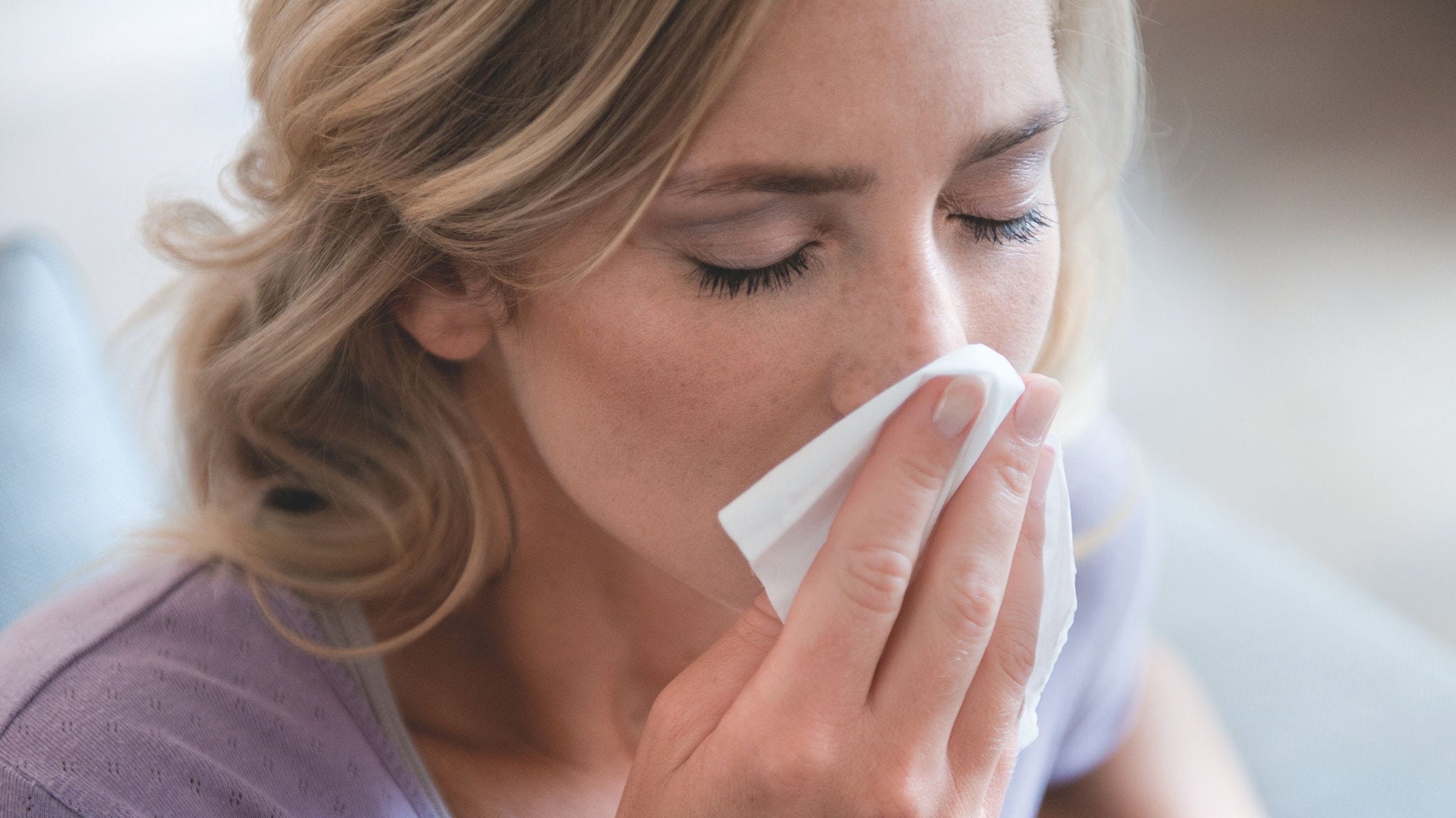 Γυναίκα που φυσάει τη μύτη της λόγω αλλεργίας στη γύρη