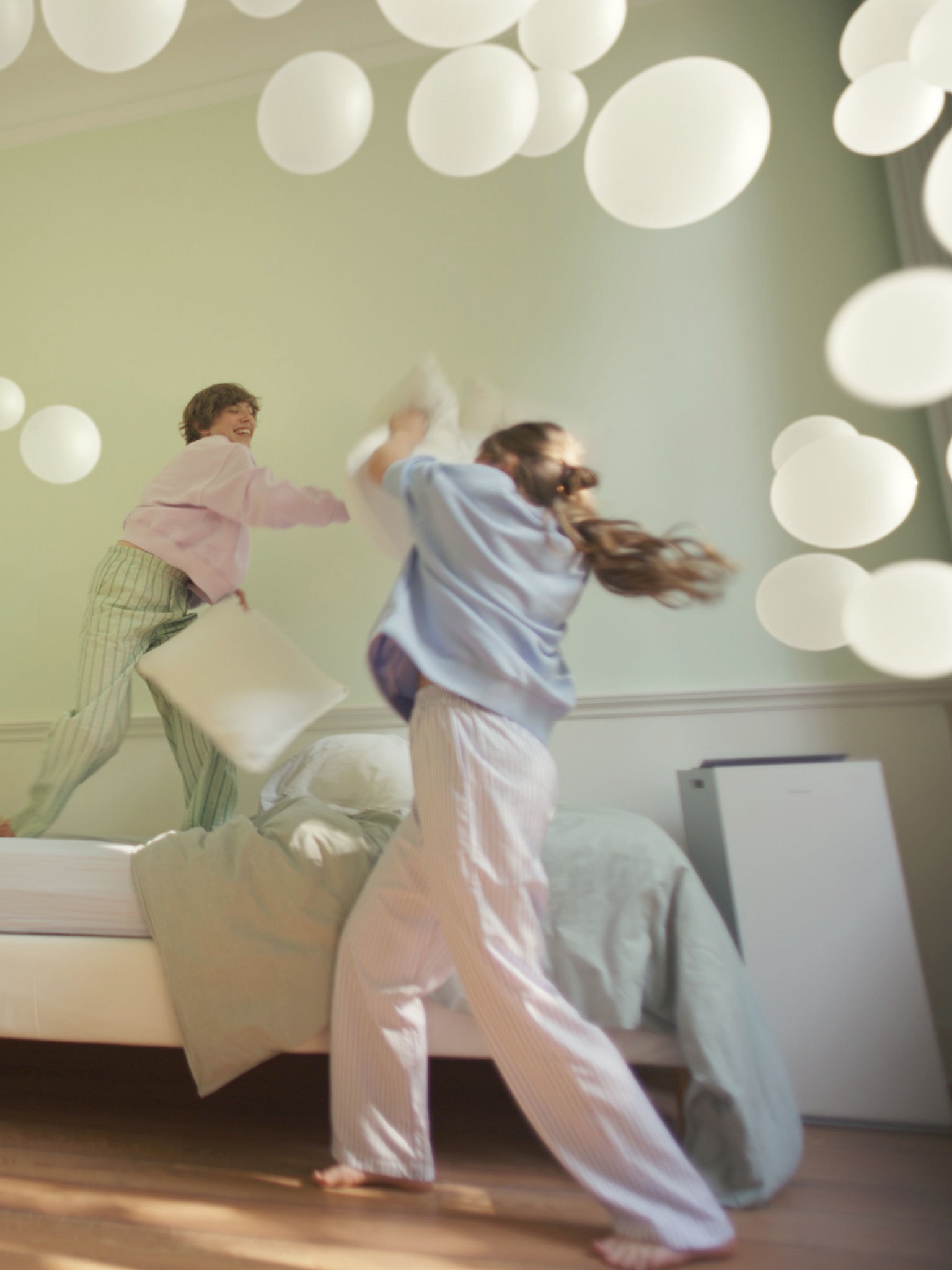 Δύο κορίτσια παίζουν σε ένα υπνοδωμάτιο με ισορροπημένη υγρασία και υποστήριξη του καθαριστή αέρα της Daikin