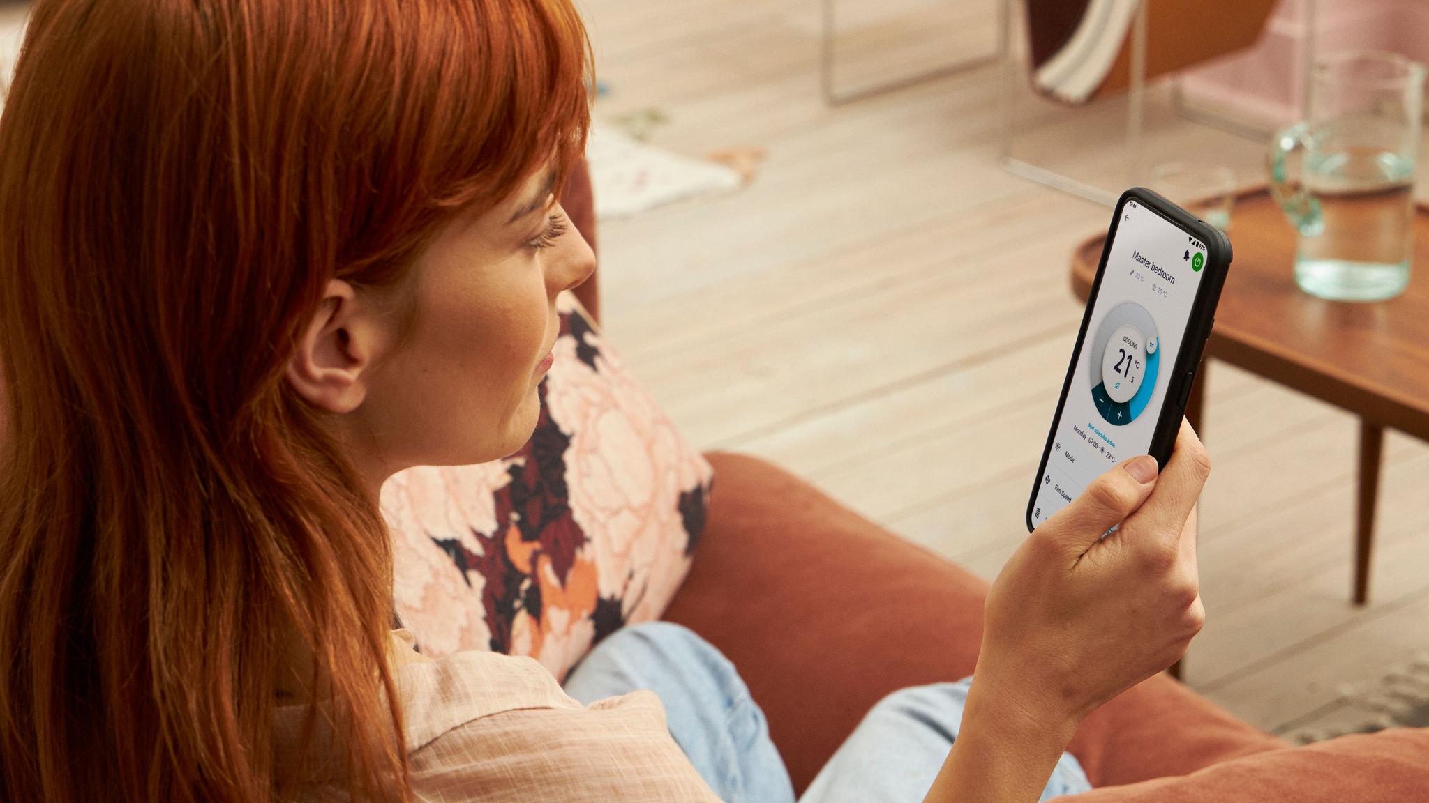 Μια γυναίκα που χρησιμοποιεί την εφαρμογή Onecta για να ελέγξει τη θερμοκρασία