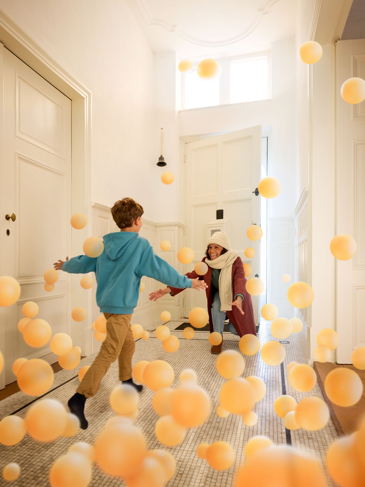 Γιος αγκαλιάζει τη μητέρα του σε έναν διάδρομο εισόδου, συμβολίζοντας την άνεση, τη ζεστασιά και την αόρατη επίδραση του καθαρού, τέλεια ισορροπημένου αέρα εσωτερικών χώρων, χάρη στην Daikin