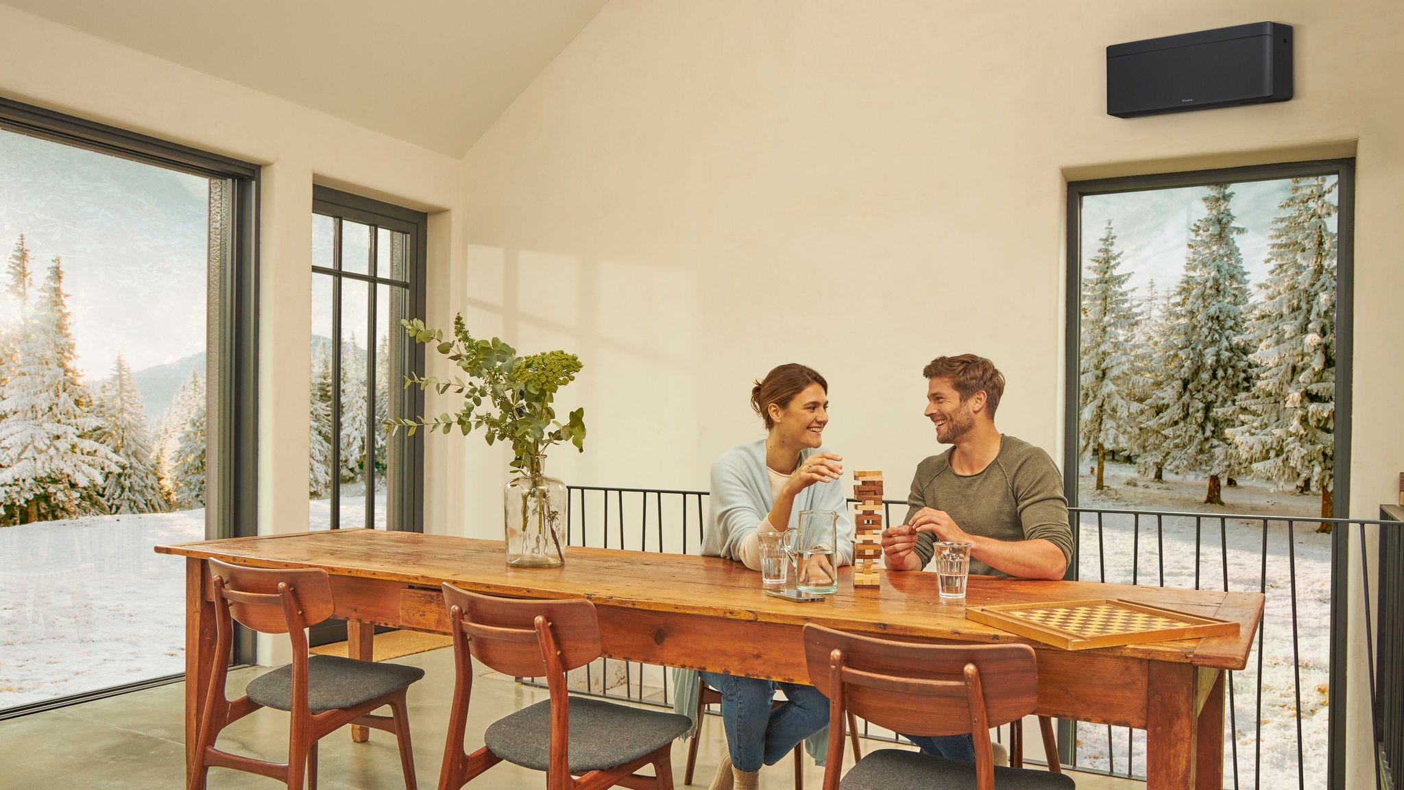 Ζευγάρι που απολαμβάνει τη θέρμανση με κλιματιστικό στο καθιστικό του