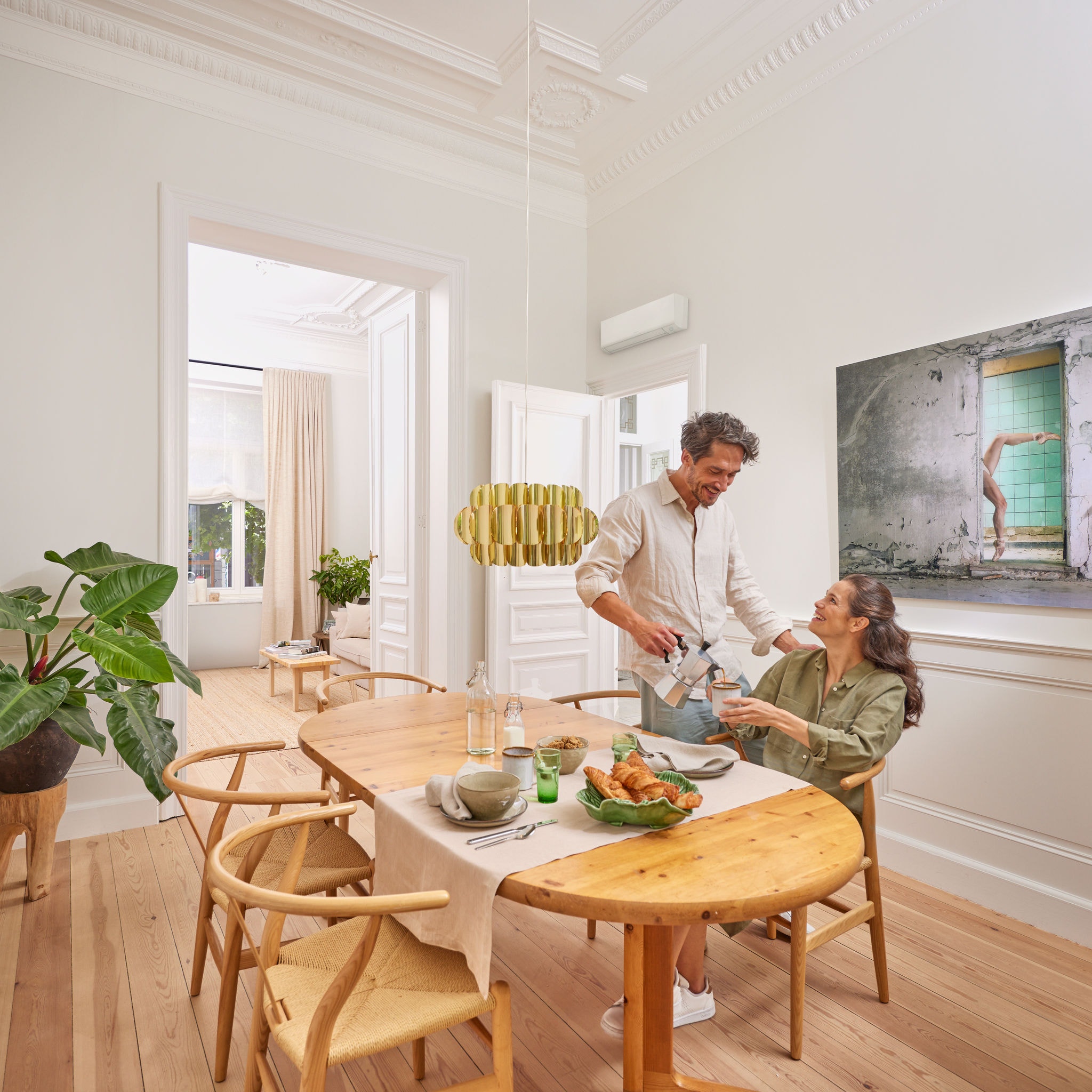 Man pouring coffee for his wife as they enjoy breakfast in their spacious dining room