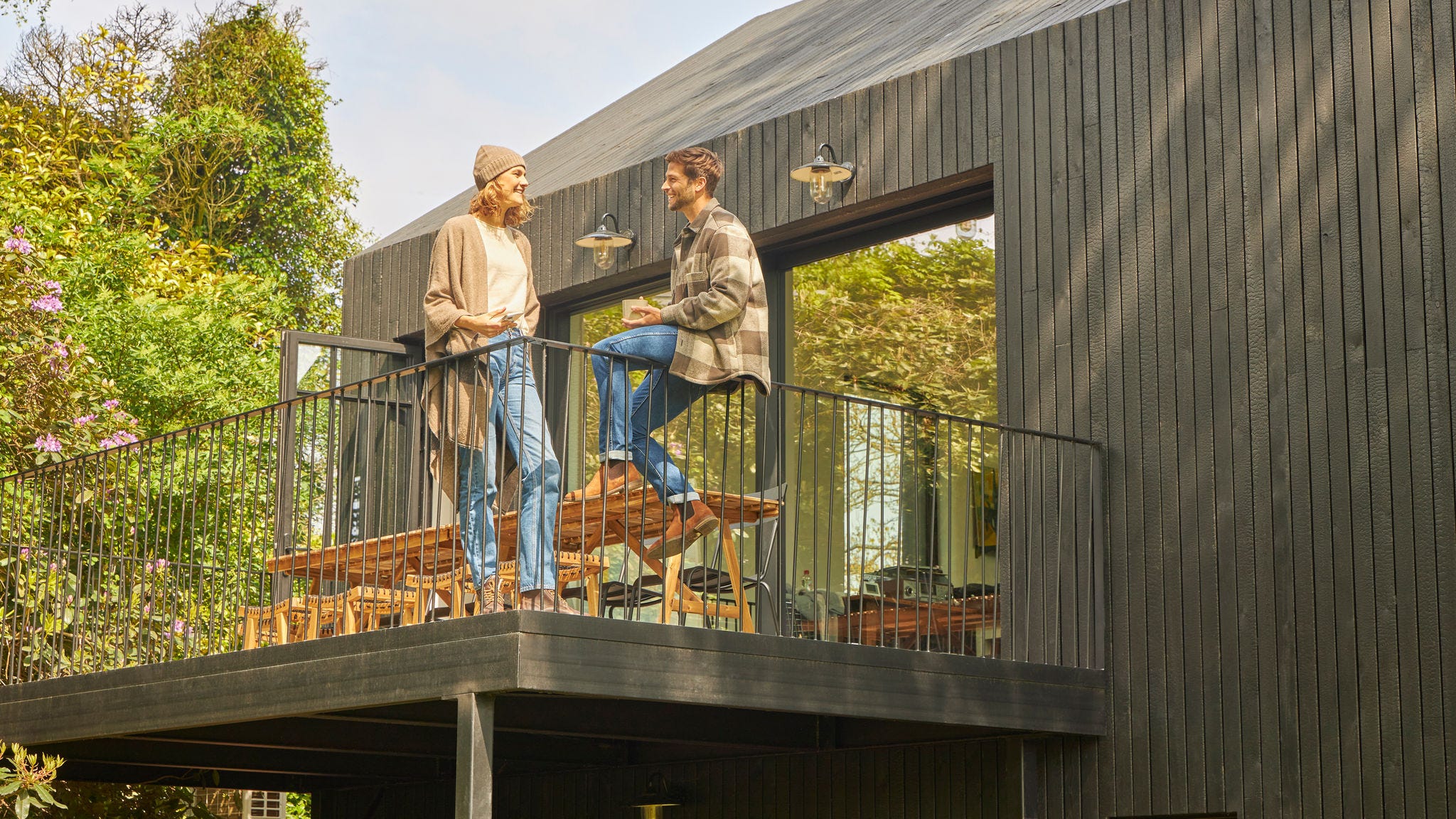 Ζευγάρι συζητάει στην αυλή ενός μπάνγκαλοου στη φύση