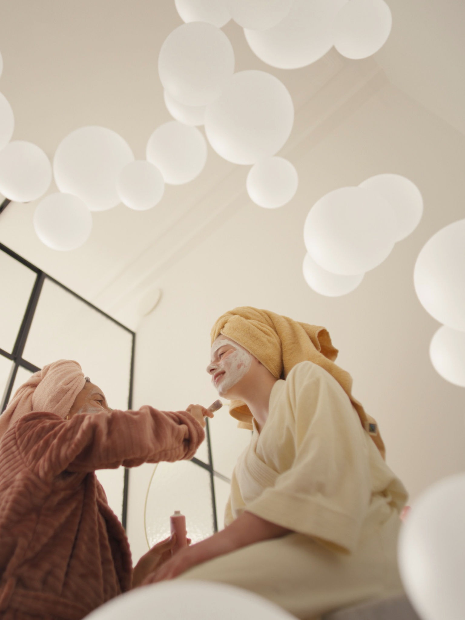 Μητέρα και κόρη απολαμβάνουν στιγμές ευεξίας με μάσκες προσώπου σε ένα καλά αεριζόμενο δωμάτιο, χάρη σε ένα σύστημα εξαερισμού φρέσκου αέρα