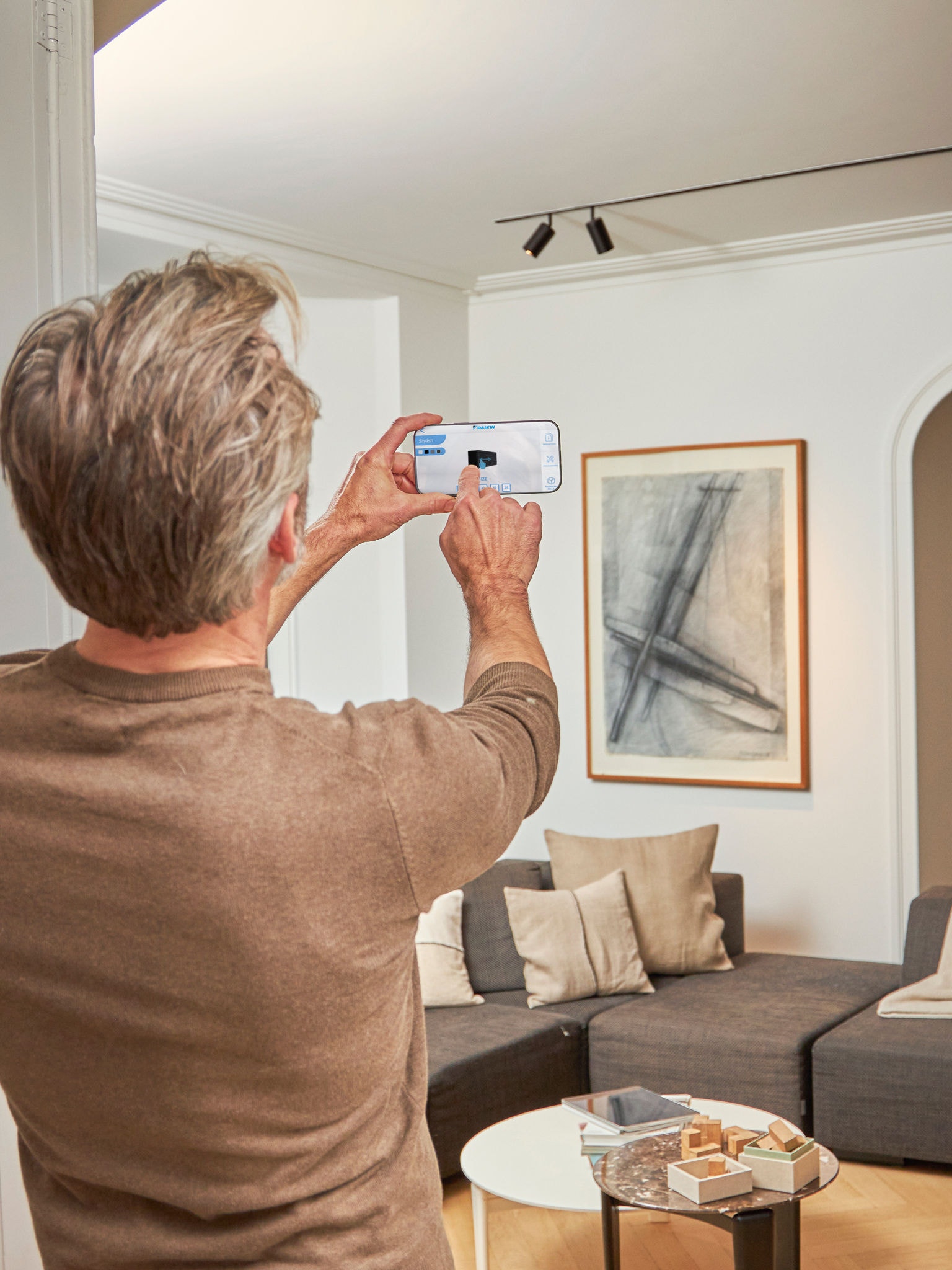 Άνδρας που χρησιμοποιεί την εφαρμογή 3D με αντλίες θερμότητας αέρα-αέρα επαυξημένης πραγματικότητας για την οπτικοποίηση των μονάδων σε συνδυασμό με τον εσωτερικό και εξωτερικό σχεδιασμό