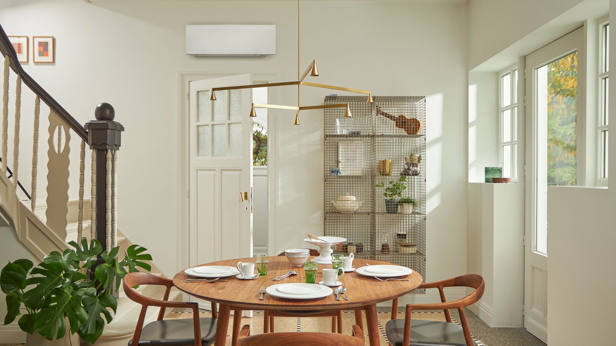 Δωμάτιο με μεγάλο παράθυρο, ξύλινο τραπέζι και μαύρη επιτοίχια λύση κλιματισμού