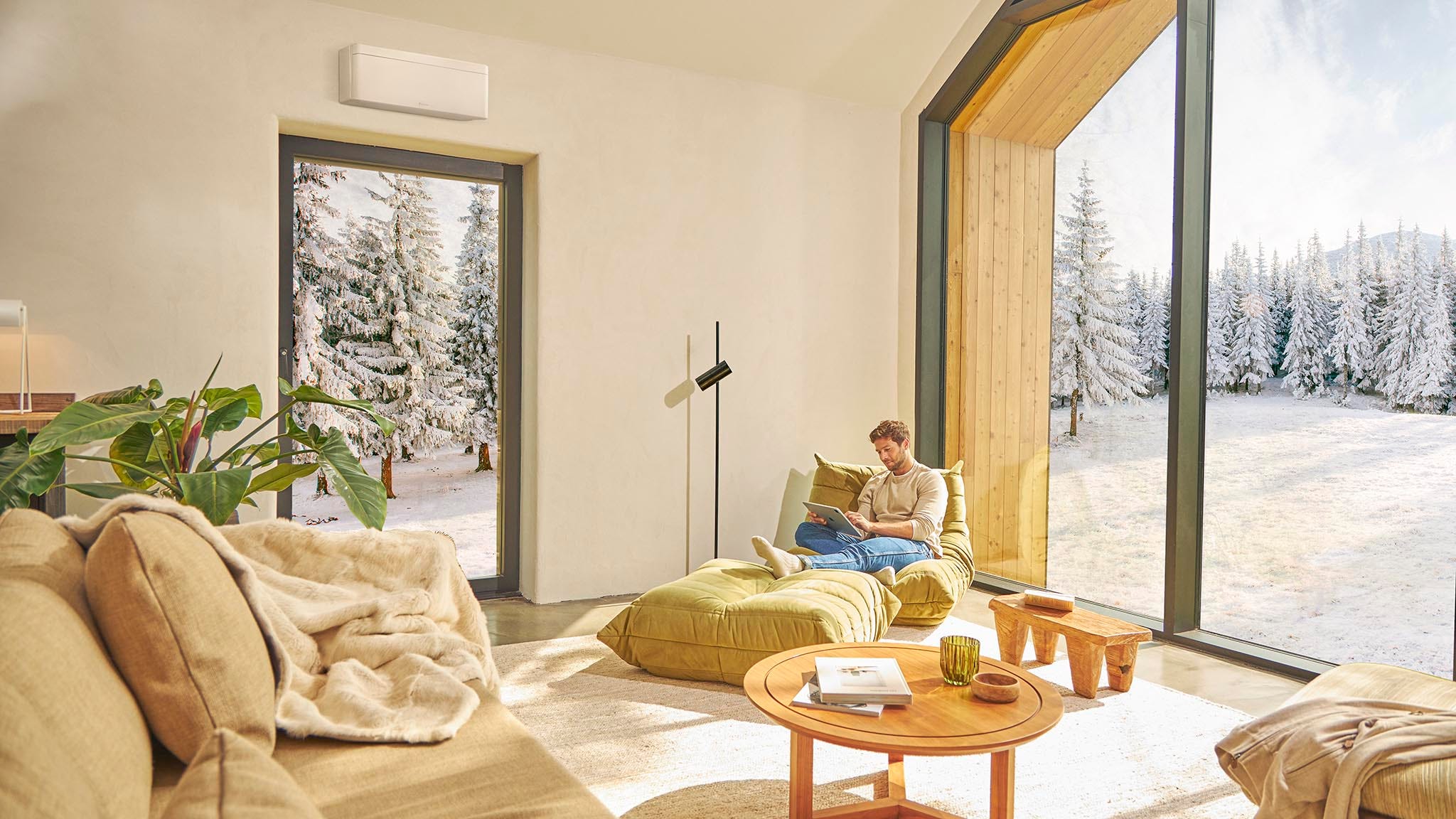 Άντρας κάθεται στον καναπέ και απολαμβάνει τη θέρμανση με κλιματιστικό