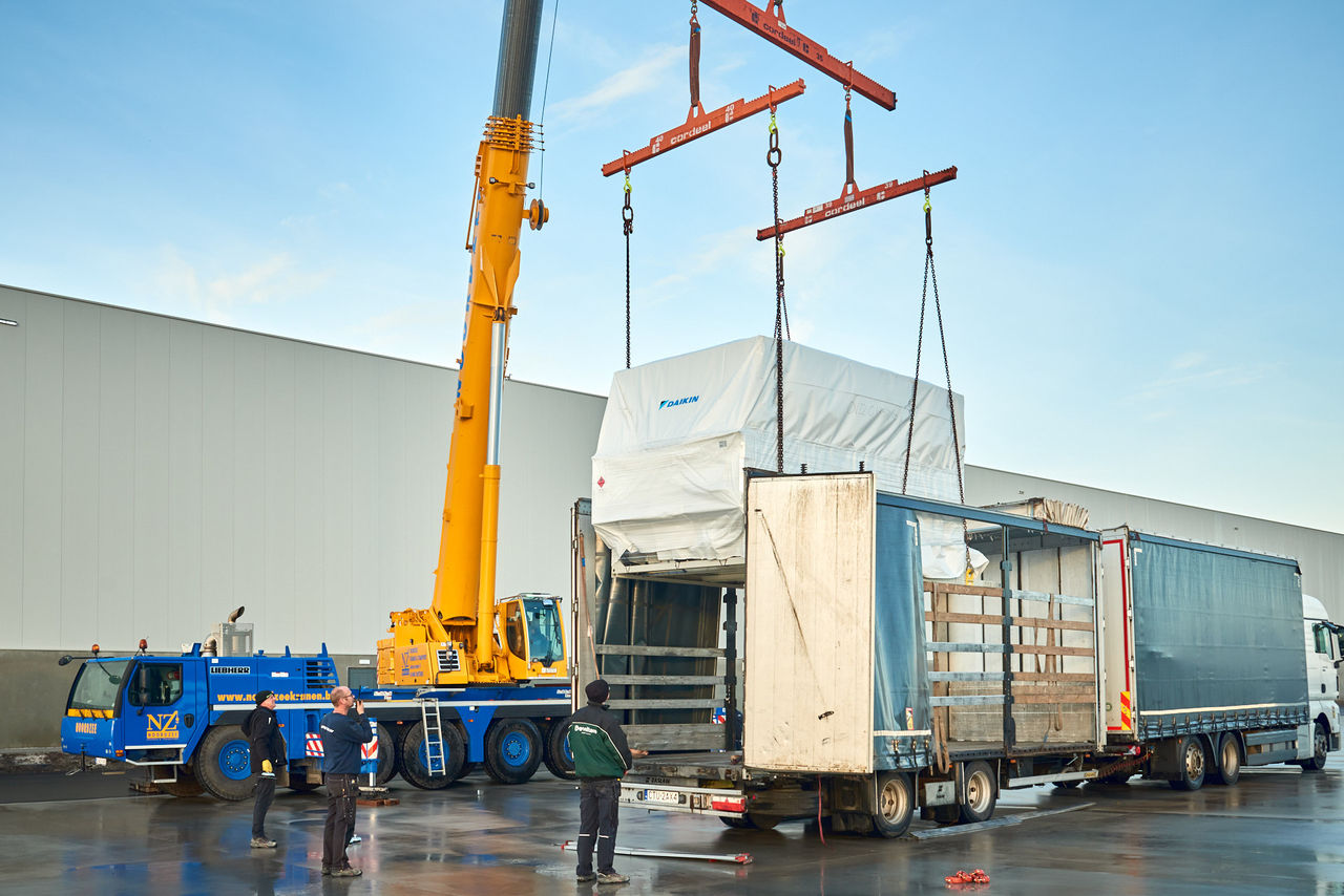 Γερανός ανυψώνει μια μονάδα HVAC για αντικατάσταση